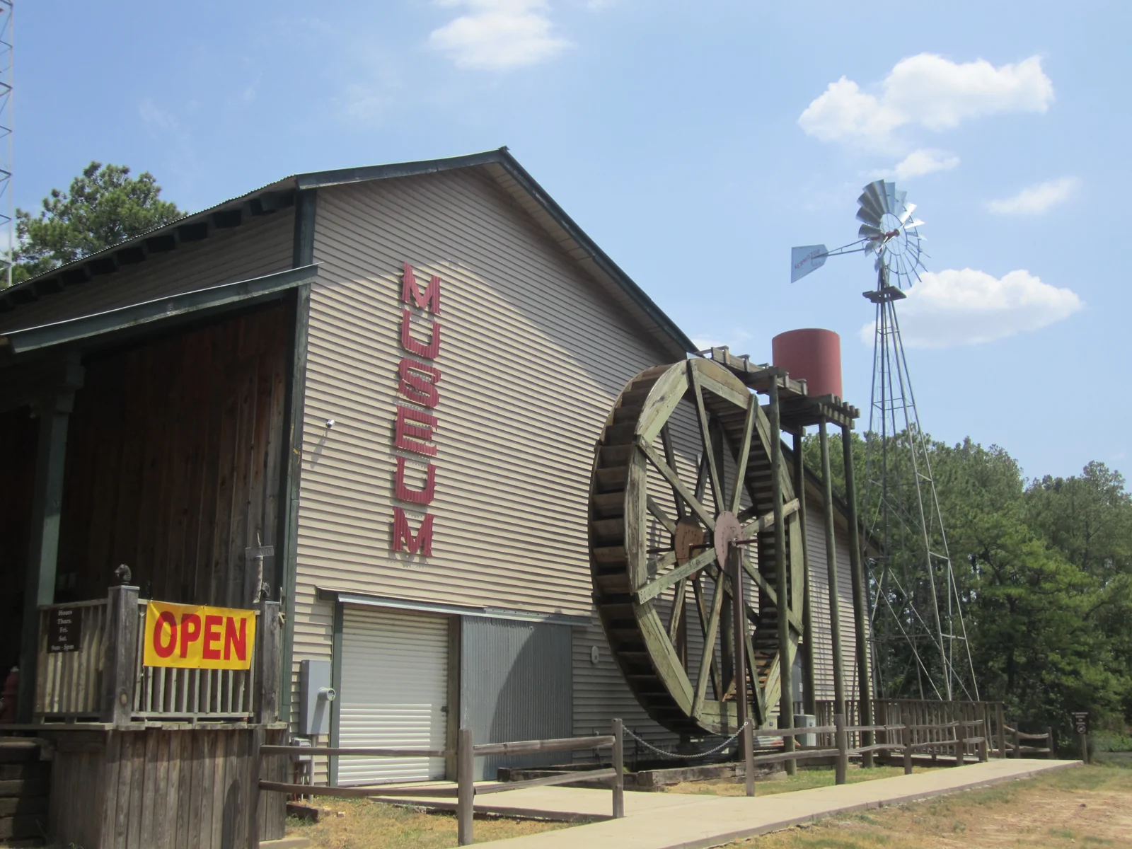 Old Mill Museum exterior with waterwheel and windmill in Lindale, Texas